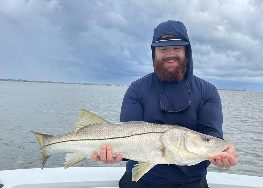 Mack holding a Common Snook on a boat