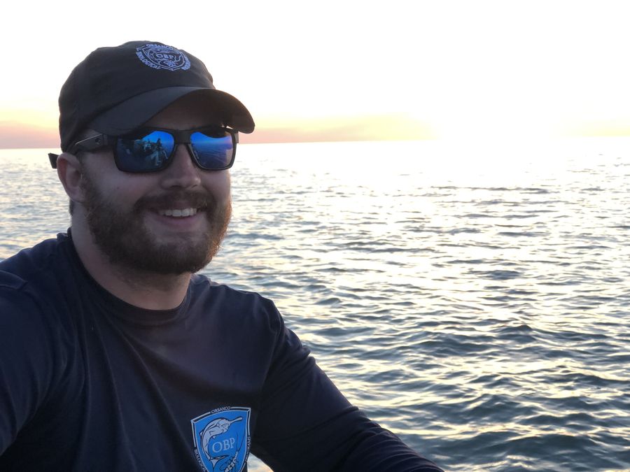 Smiling on a boat with the sun setting over open water