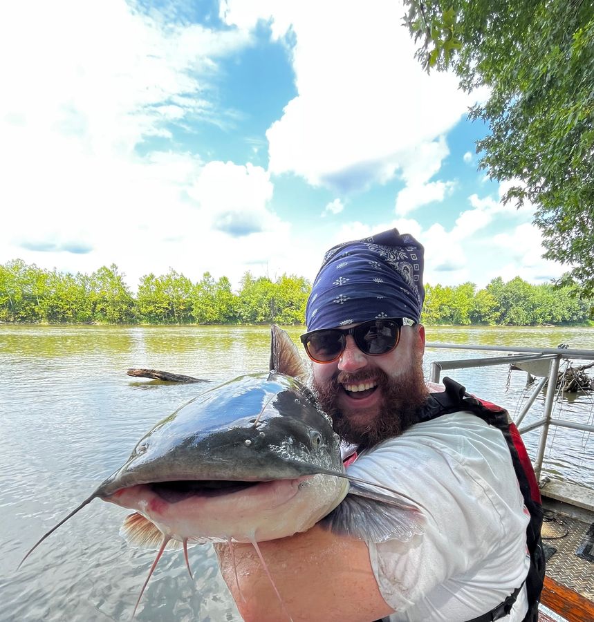 Mack grinning beside a catfish held up to the camera